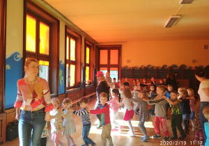 Przedszkolaki z nauczycielką podczas zabawy w pociąg